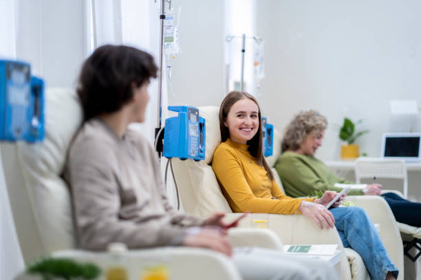 A group of people relax in recliners while receiving IV treatments.