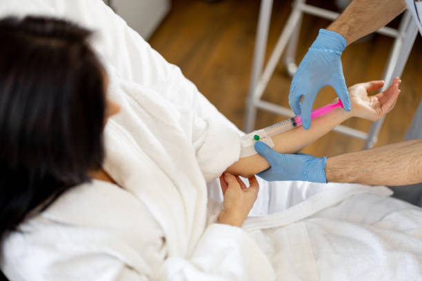 A woman receives IV fluids for dehydration from a medical provider.